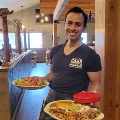 Server carrying fajitas and a combination plate