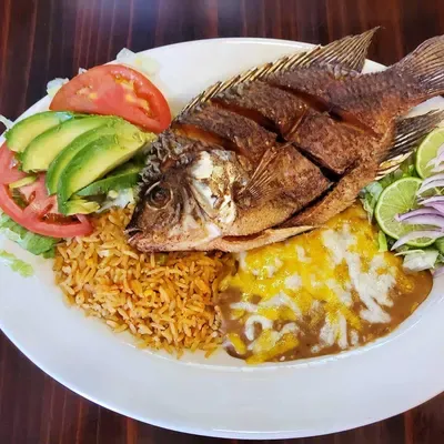 Whole fried tilapia with rice, beans, and avocado