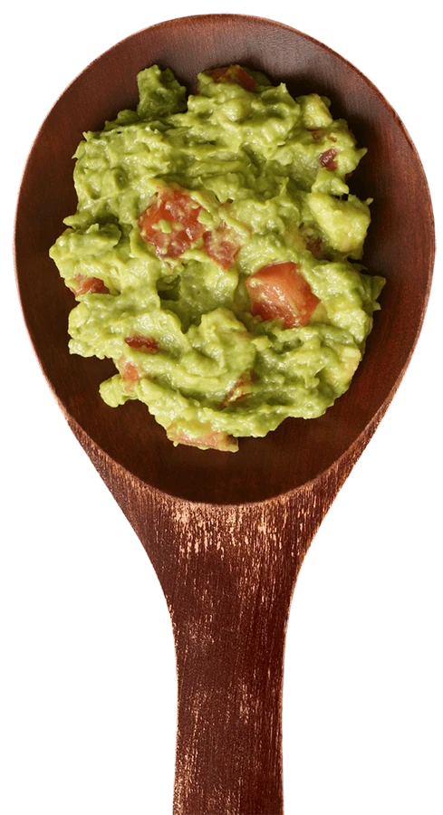 Wooden spoon piled with fresh guacamole